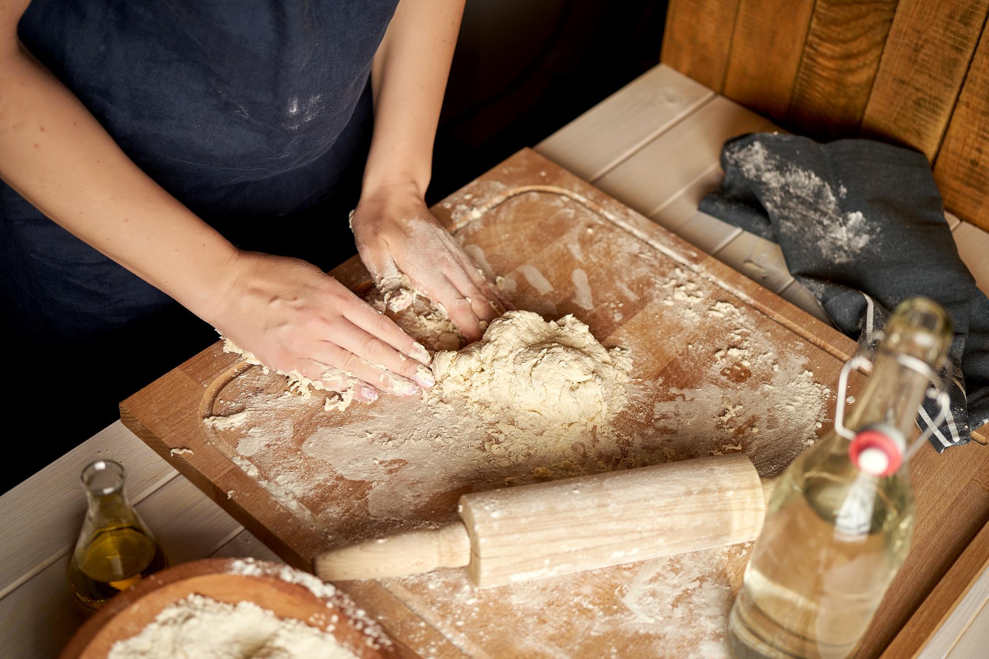 Hands shaping dough in workshop